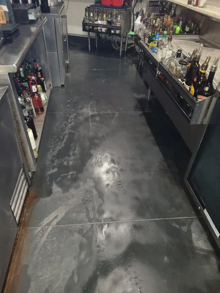 Metallic epoxy floor behind a bar